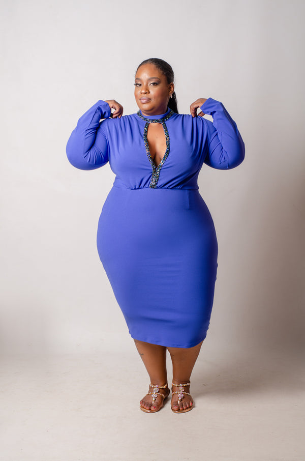 Plus-size model wearing a blue knee-length dress with long sleeves and a keyhole neckline.